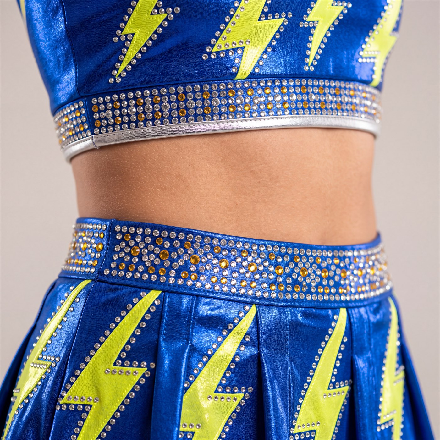 Lightning bolts and graduated stone bands across a royal blue skirt